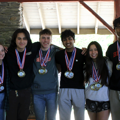 2023 Rhode Island Envirothon winners from the Wheeler School (team 1) display their medals with NRCS State Conservationist, Pooh Vonkhamdy (right), and their teacher (left).