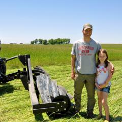 Iowa farmer Levi Lyle and his daughter Olivia stand near a tractor cab