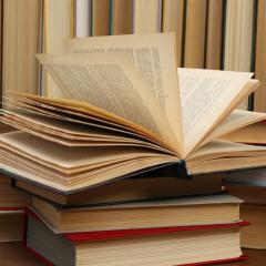 Many hardcover books as background, closeup.