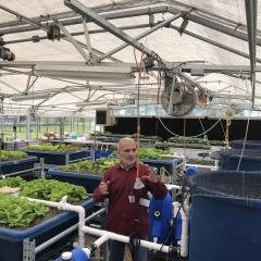 Dr. Masabni explains to the science of growing crops in urban and suburban setting with lettuce growing in an indoor vertical hydroponic farming system.