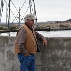 Rancher Bob Helmers stands in front of a water storage facility. 02/07/2023 Helmers Ranch, Christoval, Texas 