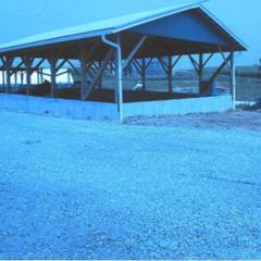 A roofed manure stacking area helps manage milk house waste and manure runoff.