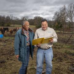 An NRCS employee discusses a conservation plan with a farmer.