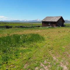 house in a field with mountains in the background
