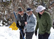 Hydrologists demonstrate a sample collection at a snow telemetry site in Utah.