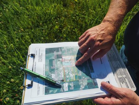 Troy Manges, Indiana NRCS district conservationist in Marshall County, inspects the restoration map of John Bellman’s Wetland Reserve Easement during a tour June 14, 2022.