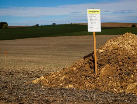 Pile of soil with a pit card sign