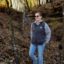 Woman standing in front of a woodland rock feature