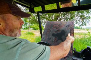 Tom Dykstra looks at a map while giving a tour June 7, 2022 of the 110-acre wetland reserve easement located in Fremont, Indiana he purchased in 2015. 