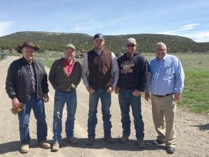 five men standing on a dirt road