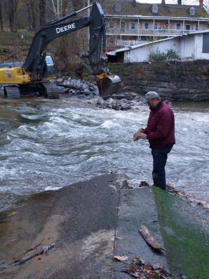 Mr. Dunne Inspects a piece of the breached dam