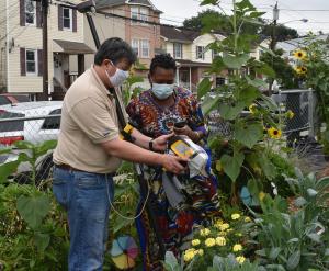 Soil Scientist Edwin Muniz shows a producer the readings from her garden. 