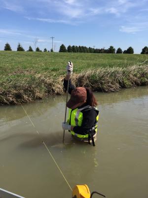 A water quality sample is collected in School Branch Creek