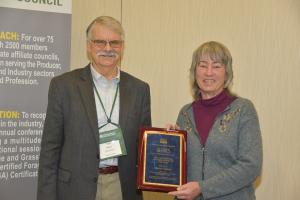 Marty Chaney (Right) poses with Tom Hilken (left) holding a plaque after she was awarded 2022 Pastureland Conservationist of the Year