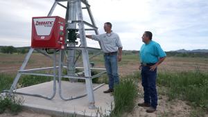 Two men standing around irrigation equipment