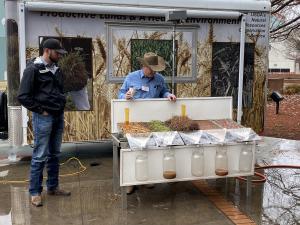 Trent Manley and John Sackett give a soil health demonstration with the rainfall simulator.