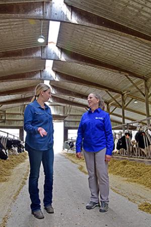 Dairy operator Ann Deering (left) speaks with NRCS District Conservationist LuAnn Rolling about her energy-efficient lighting system.