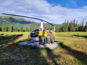 Alaska field staff standing by a helicopter.