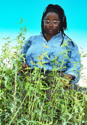 A lady stands outside looking at plants on Shield Ranch