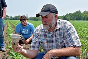 Jason Steele looks at water infiltration rates on a southeast Iowa farm during soil health training.
