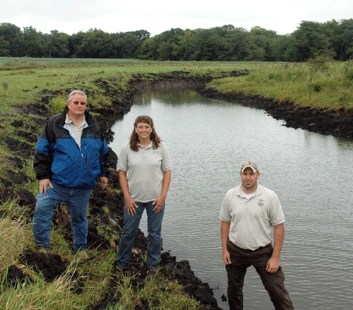 (From Left) NRCS District Conservationist Kevin Kordick, Soil Conservation Technician Carolyn Schwartz and U.S. Fish and Wildlife Service Biologist Kraig McPeek stand near Terry Adams� newly restored oxbow.