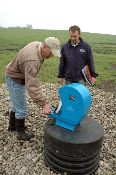 To provide water to cows in three of seven paddocks, Mike Sweeney used a tile line from his pond and an ag waterway to animal powered nose pumps. Sweeney, left, shows NRCS Soil Conservationist Ryan Gerlich how the pumps work. In the other four paddocks, the cows have access to water in Camp Creek at the crossing locations.