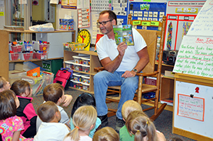 Brad Harrison reads one of the WhoBuddies books he authored to kindergartners at Brookview Elementary School in West Des Moines in 2012.